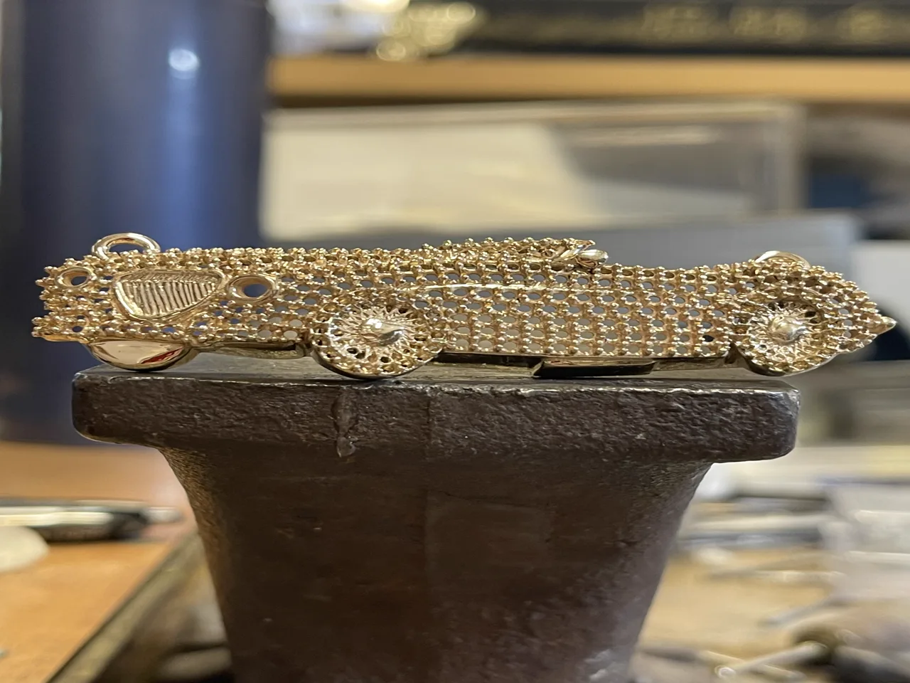 Custom car-inspired pendant with sculpted details and polished metalwork.
