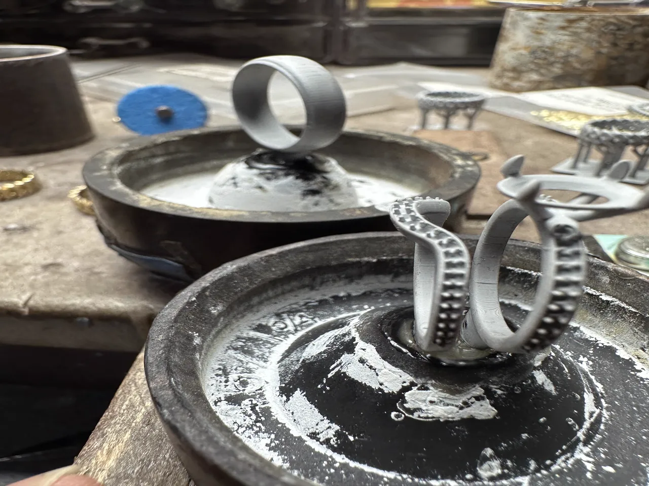 Freshly cast jewelry pieces on a sprue tree before separation and finishing.